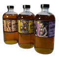 Three bottles of alcohol with decorative labels on a white background